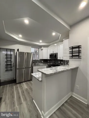 a view of kitchen with stainless steel appliances granite countertop a stove and a refrigerator