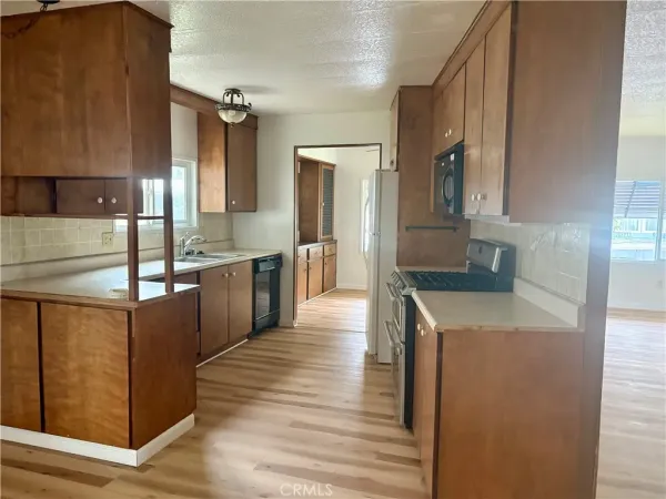 a kitchen with stainless steel appliances granite countertop a sink and wooden cabinets