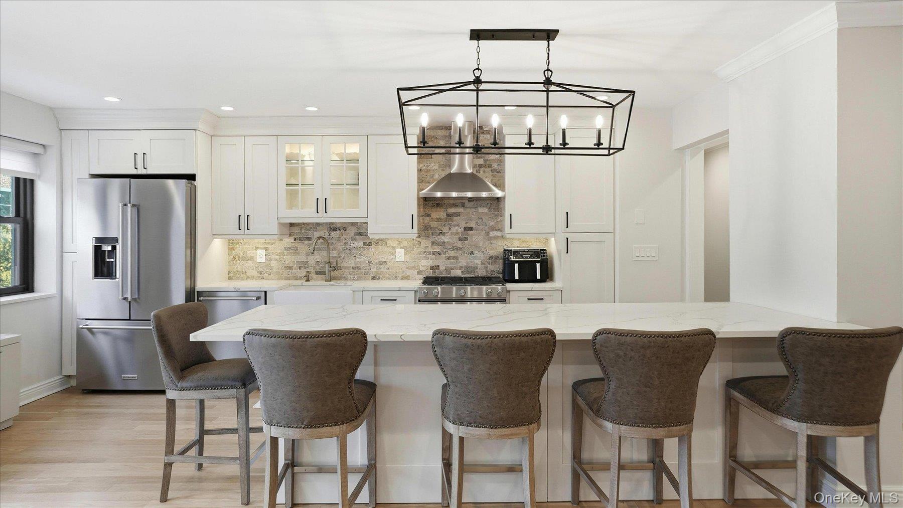a kitchen with stainless steel appliances granite countertop a dining table and chairs