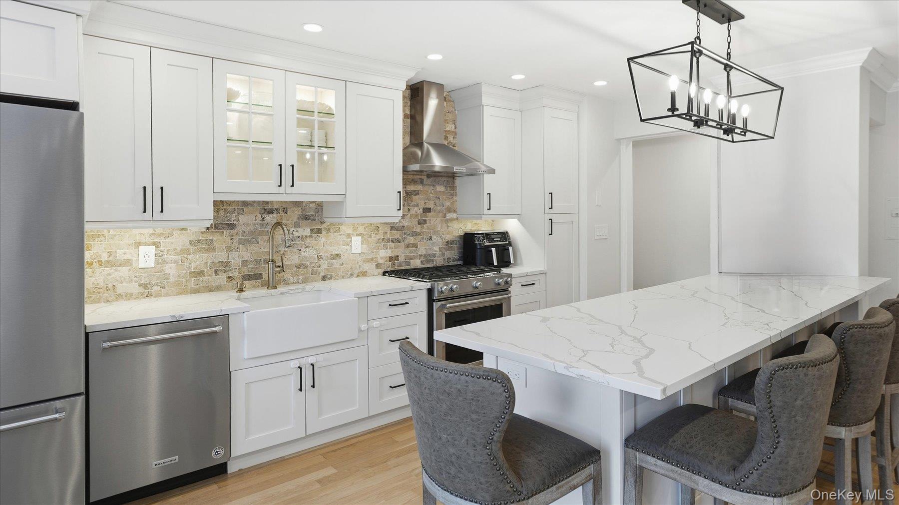 22 Park Place, Unit 4T Great Neck, NY 11021 - Photo 2 of 13 a kitchen with a table chairs microwave and cabinets