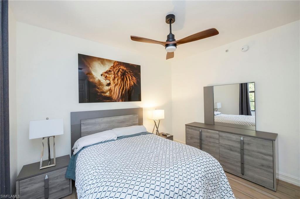 9145 Chula Vista Street, Unit 13004 Naples, FL 34113 - Photo 15 of 24 a bedroom with a large bed and a chandelier