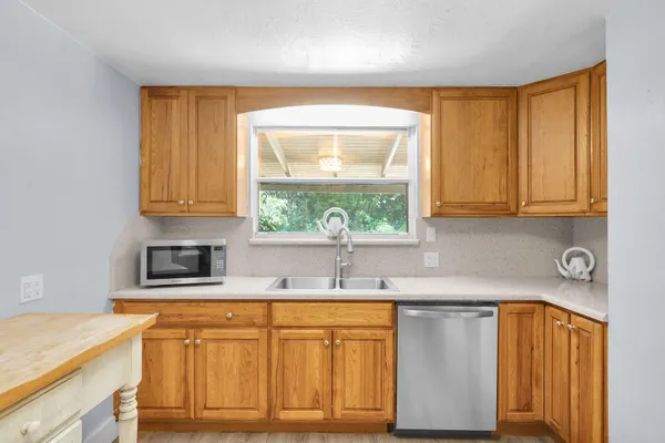 a kitchen with stainless steel appliances granite countertop a sink a stove and cabinets