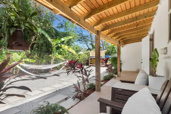 a backyard of a house with table and chairs plants