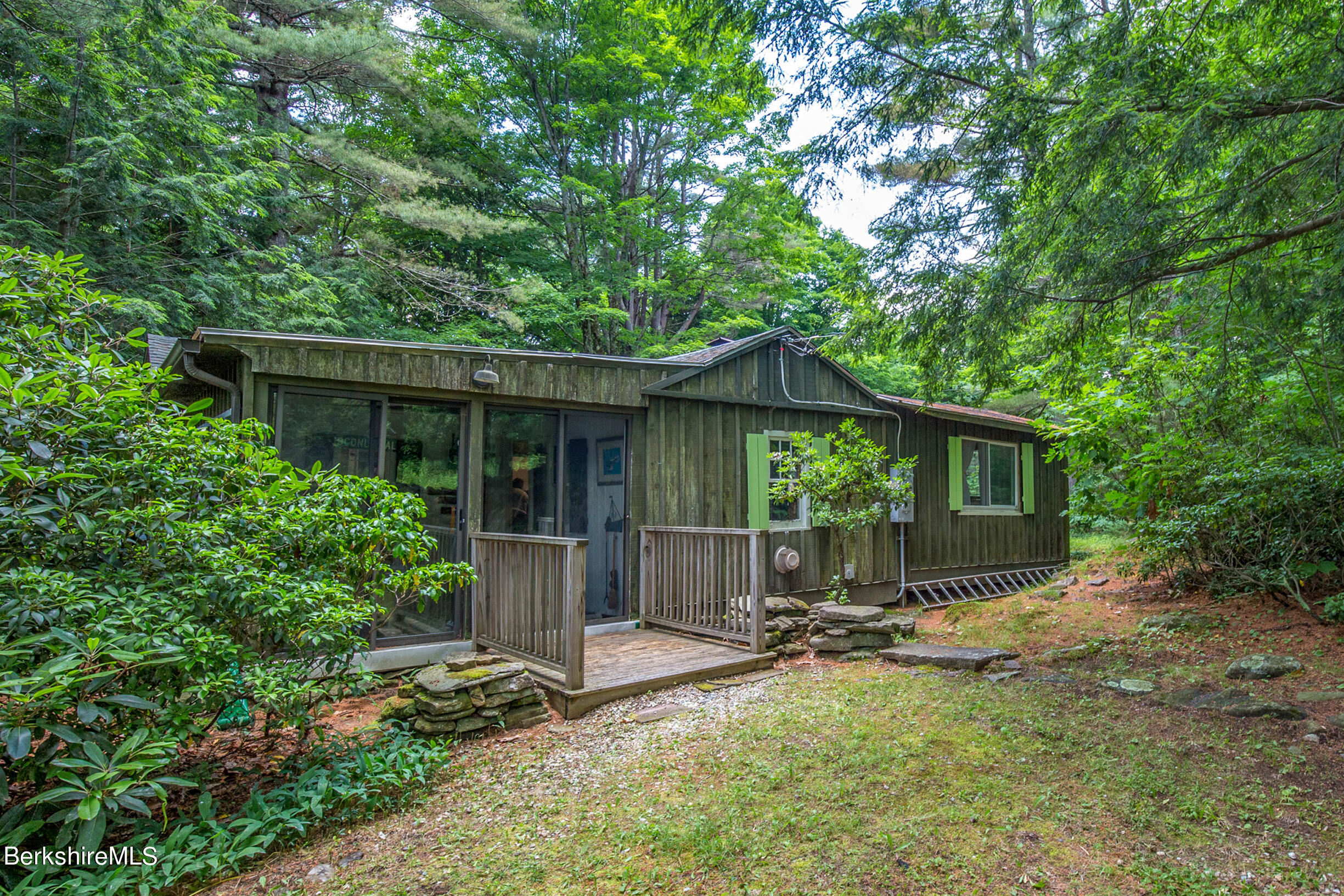 1146 East Otis Road Otis, MA 01029 - Photo 1 of 20 a backyard of a house with table and chairs under an umbrella