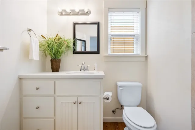 a bathroom with a toilet a sink and mirror