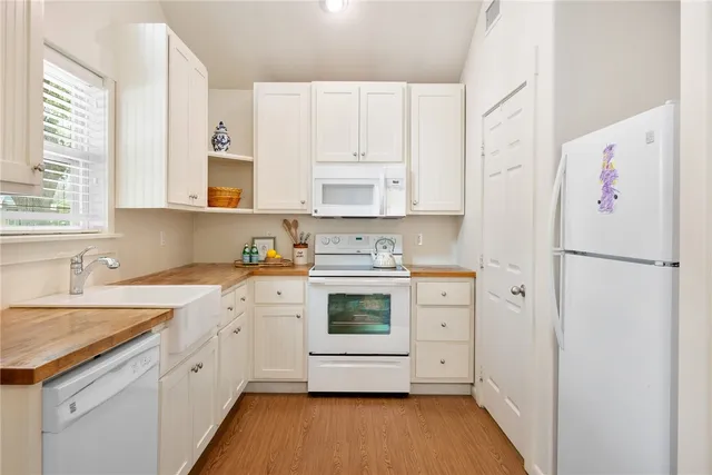 a kitchen with white cabinets and white appliances