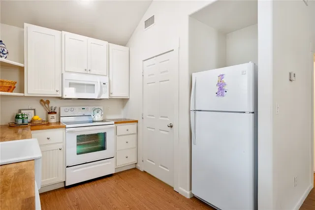 a kitchen with a refrigerator sink stove and white cabinets