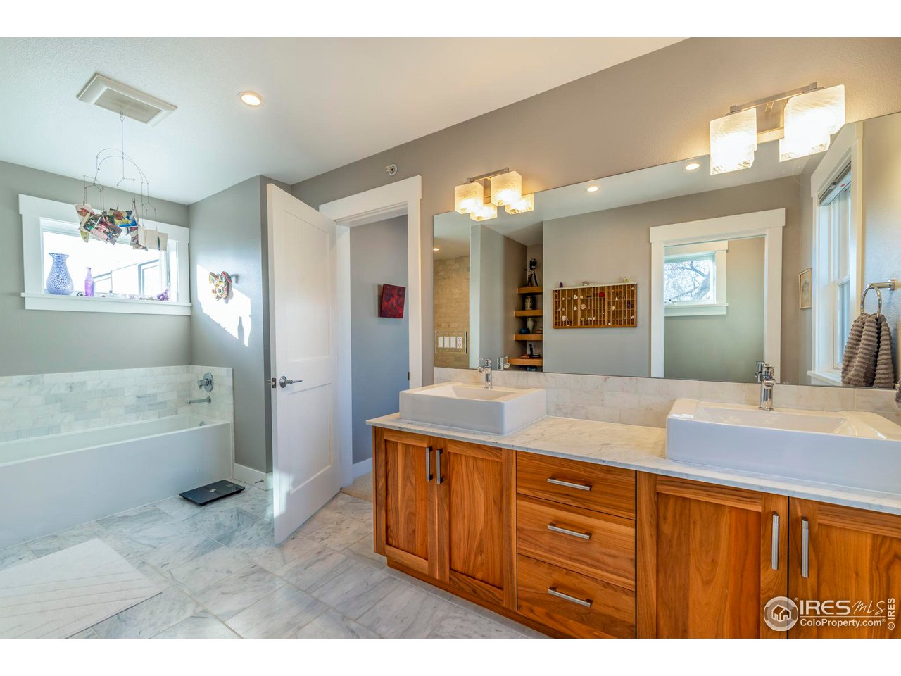 2058 Walnut Street, Unit A Boulder, CO 80302 - Photo 23 of 38 a bathroom with a granite countertop sink a bathtub a mirror and a shower