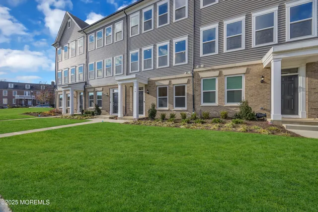a front view of building with yard and outdoor seating