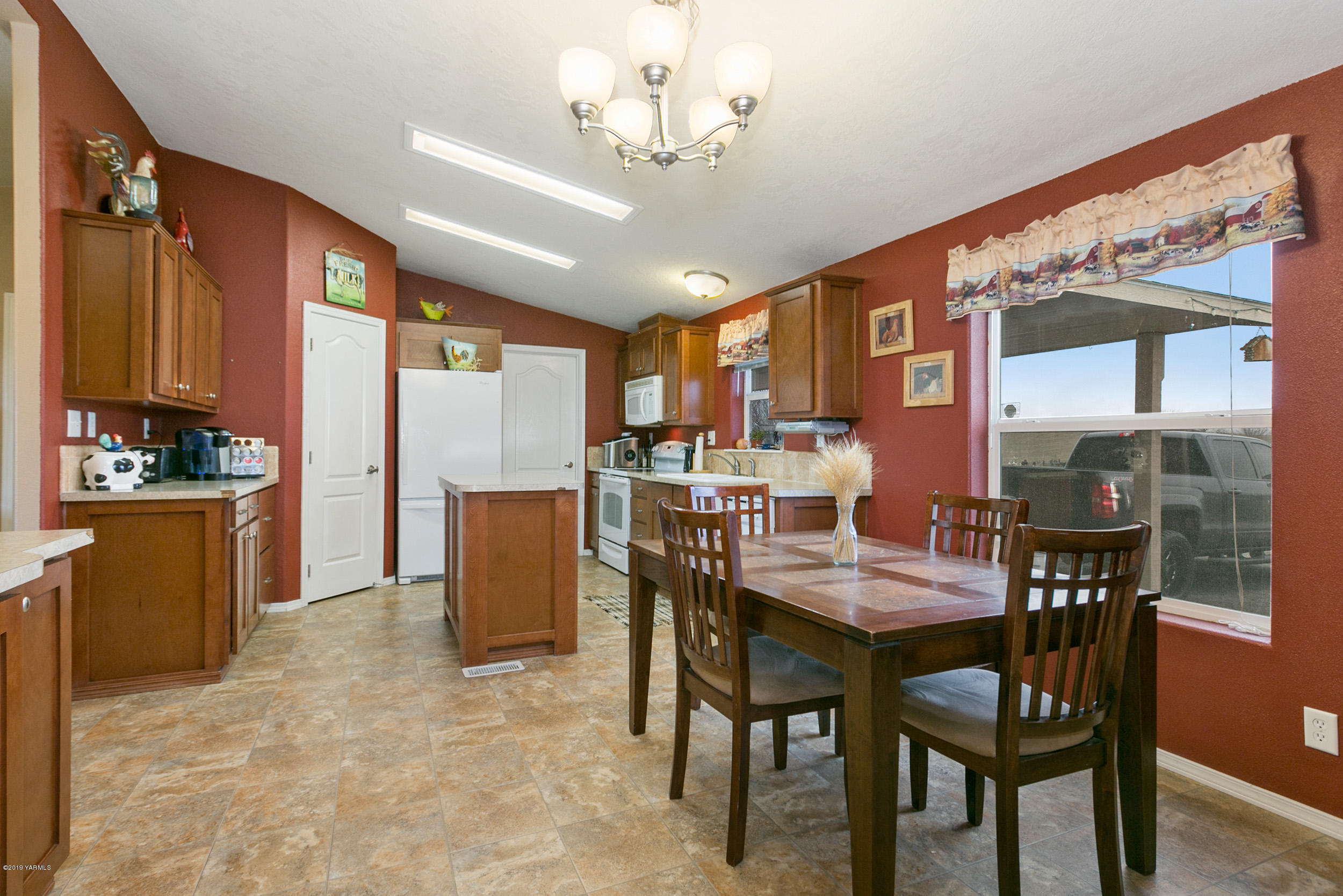 177 Division Road Zillah, WA 98953 - Photo 11 of 23 a dining room with furniture a kitchen view and a chandelier