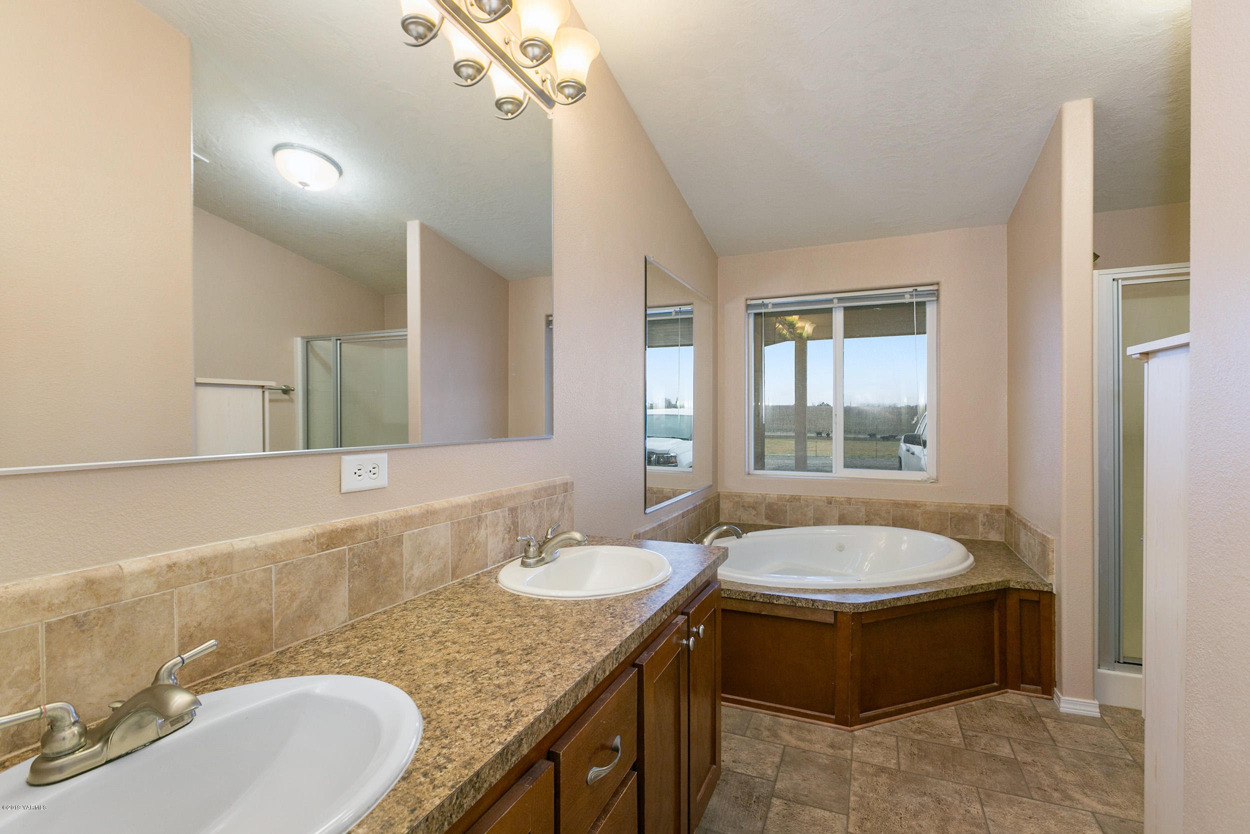 177 Division Road Zillah, WA 98953 - Photo 15 of 23 a bathroom with a granite countertop tub sink and mirror