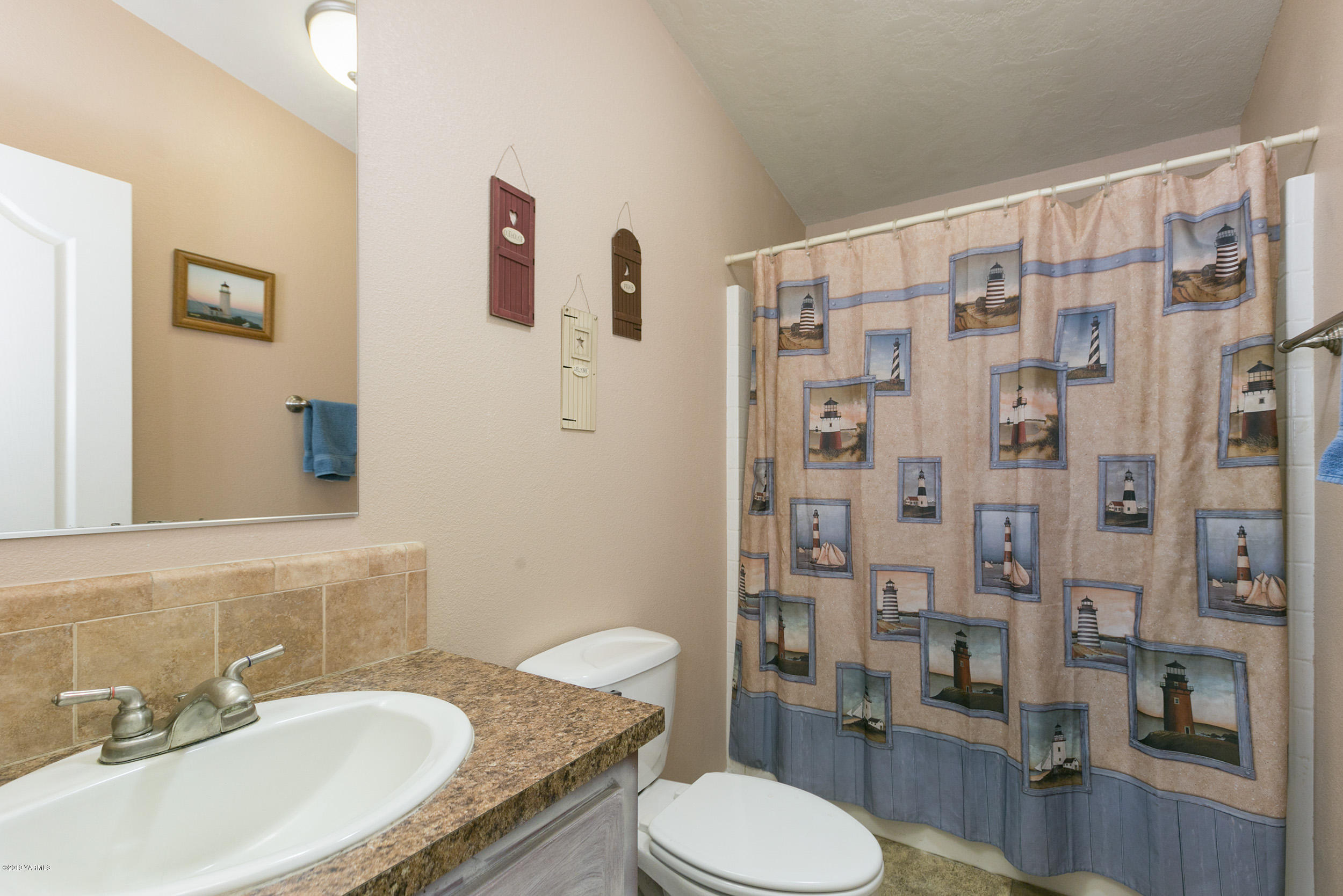177 Division Road Zillah, WA 98953 - Photo 18 of 23 a bathroom with a granite countertop sink toilet a mirror and shower