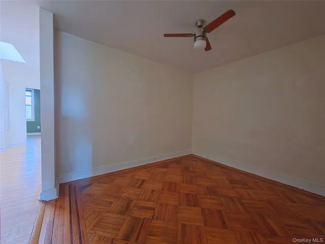 a view of a room with wooden floor and a ceiling fan