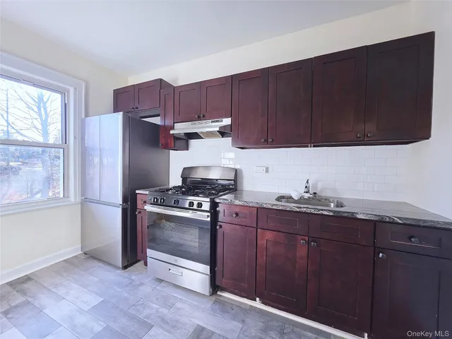 a kitchen with wooden cabinets and stainless steel appliances