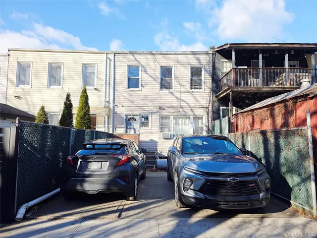 a couple of cars parked in front of a house