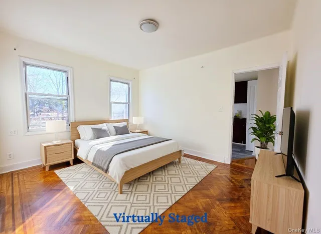 a bedroom with a bed lamp on desk and a window