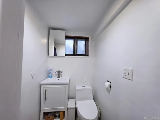 a bathroom with a toilet a sink and mirror
