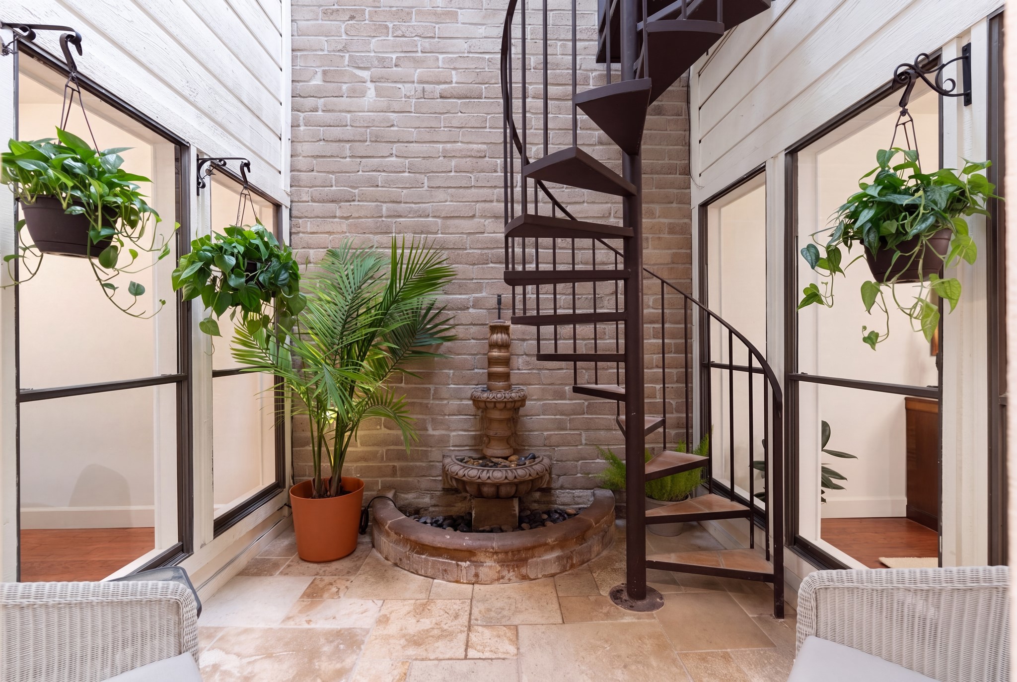 153 Sage Road Houston, TX 77056 - Photo 14 of 36 One of the home’s most distinctive spaces, the enclosed atrium features a new skylight, charming fountain and spiral staircase leading to the upstairs game room. Use it as a light-filled sitting area, wine room, art gallery or intimate spot for morning coffee and evening cocktails.