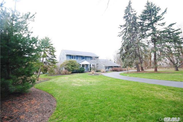 a view of a house with a big yard and large trees