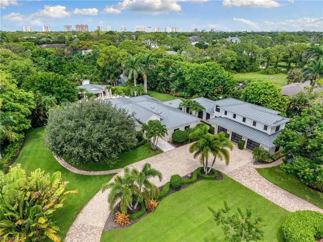 an aerial view of a house with a yard and lake view