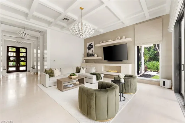 a living room with furniture a chandelier and a flat screen tv