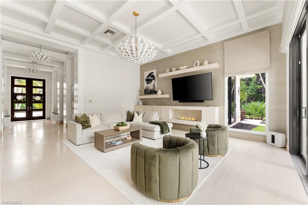 233 Ridge Drive Naples, FL 34108 - Photo 11 of 39 a living room with furniture a chandelier and a flat screen tv