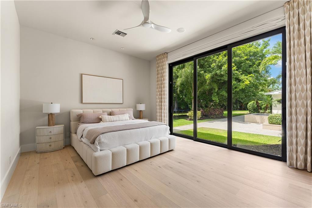 233 Ridge Drive Naples, FL 34108 - Photo 17 of 39 a bedroom with a large bed and a large window