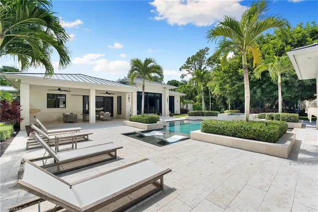 a view of a house with backyard and sitting area