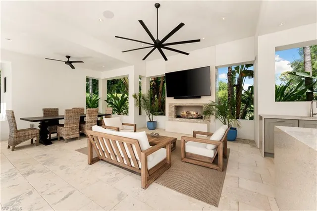 a living room with furniture a flat screen tv and a large window