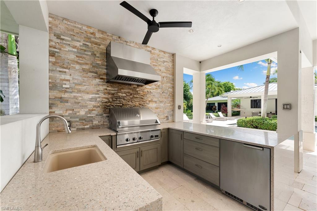233 Ridge Drive Naples, FL 34108 - Photo 31 of 39 a kitchen with stainless steel appliances granite countertop a sink stove and refrigerator