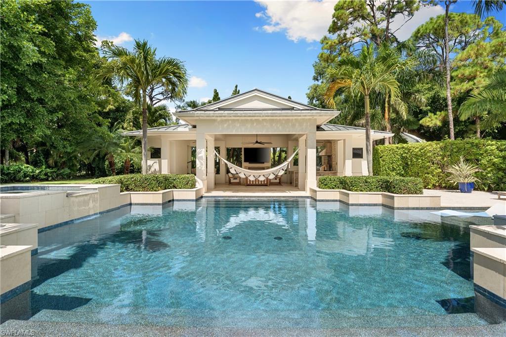 233 Ridge Drive Naples, FL 34108 - Photo 5 of 39 a view of a patio with a table and chairs next to a yard