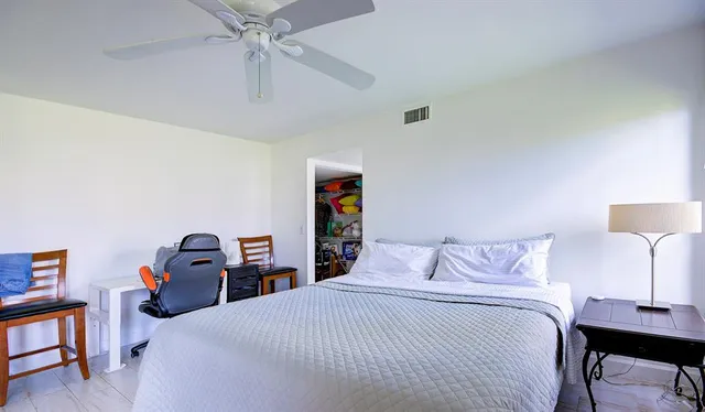 a bedroom with a bed and a lamp on a dresser