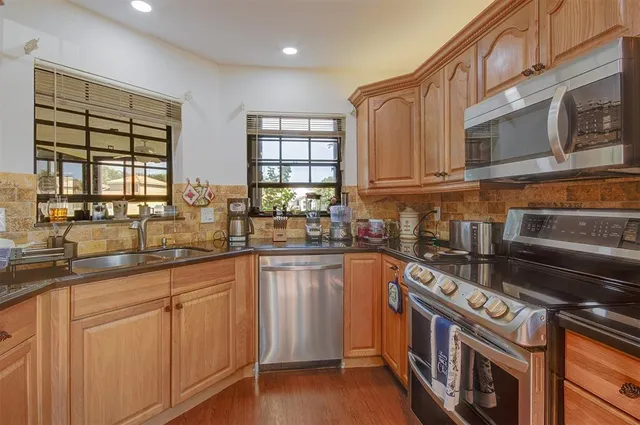 a kitchen with stainless steel appliances granite countertop a stove and a sink