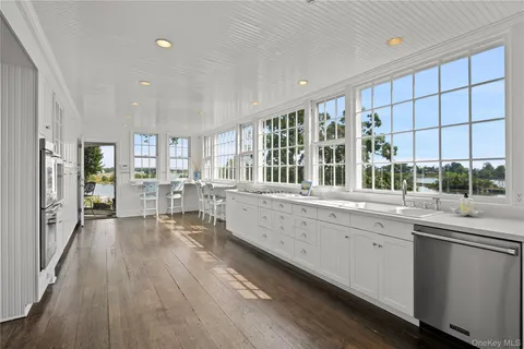a large kitchen with lot of counter space and wooden floor