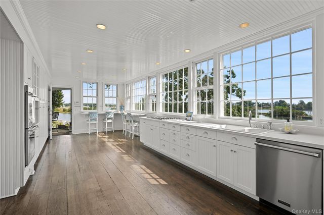 a large kitchen with lot of counter space and wooden floor