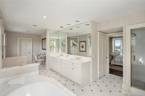 a bathroom with a bathtub sink and mirror