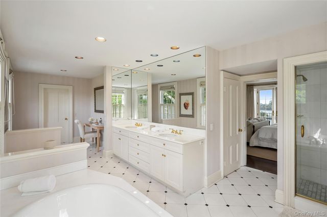 a bathroom with a bathtub sink and mirror