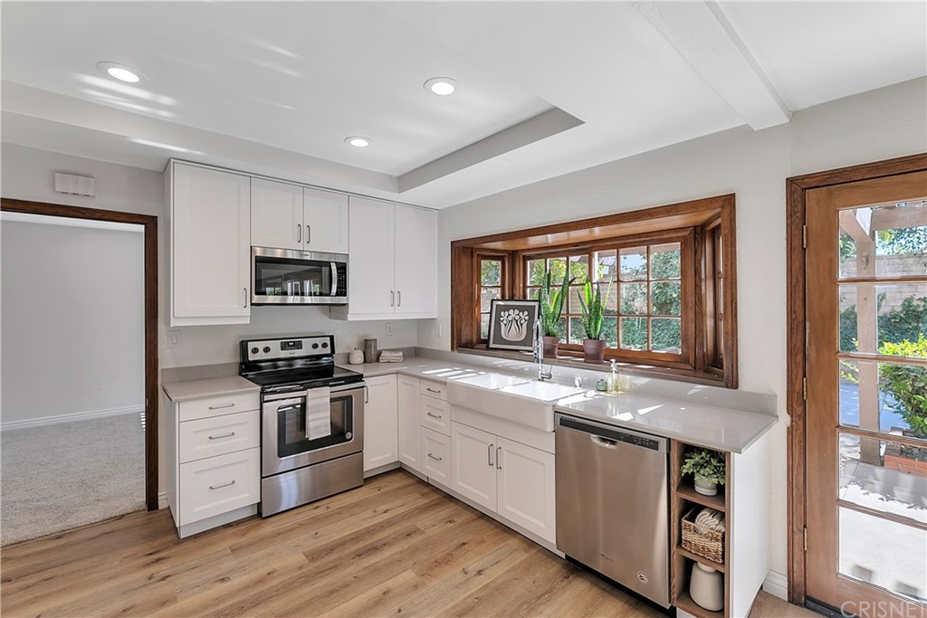 23646 Vía Corsa Valencia, CA 91355 - Photo 13 of 55 a kitchen with stainless steel appliances granite countertop a stove and a sink