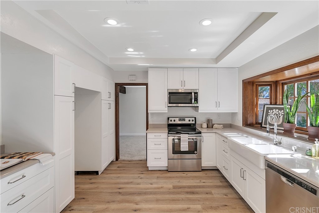 23646 Vía Corsa Valencia, CA 91355 - Photo 14 of 55 a large kitchen with stainless steel appliances granite countertop a stove and a sink