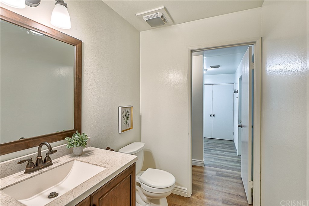23646 Vía Corsa Valencia, CA 91355 - Photo 25 of 55 a bathroom with a sink vanity granite toilet and a mirror