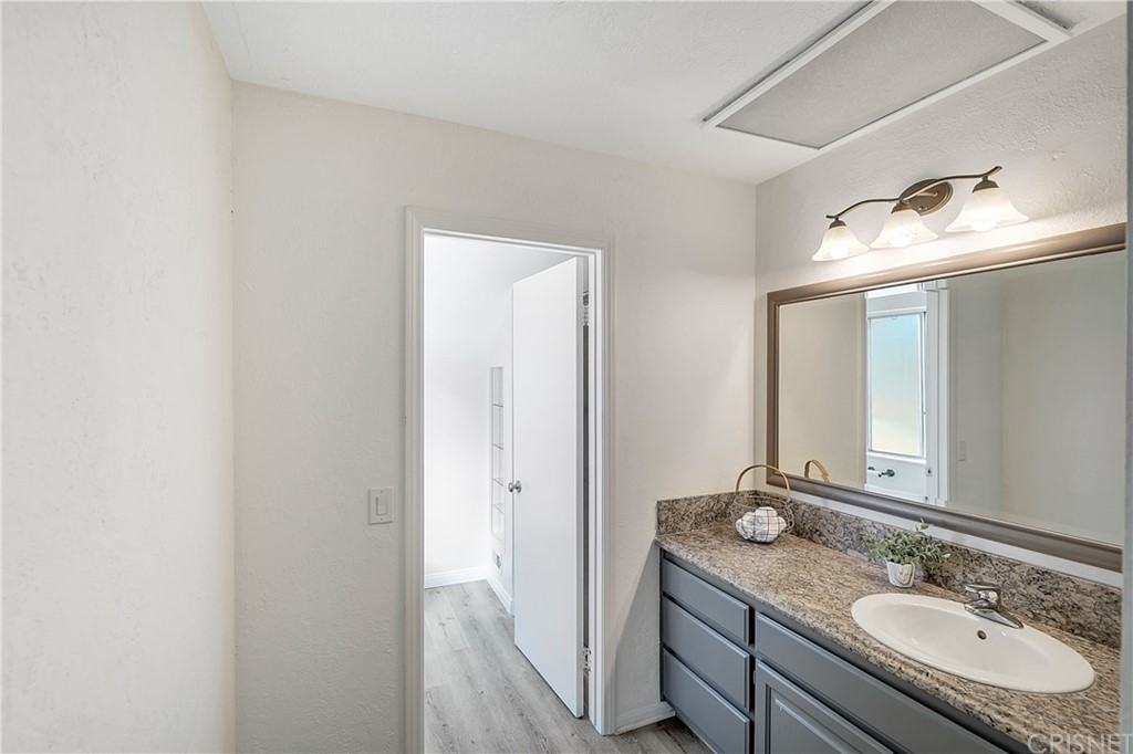 23646 Vía Corsa Valencia, CA 91355 - Photo 29 of 55 a bathroom with a granite countertop sink and a mirror
