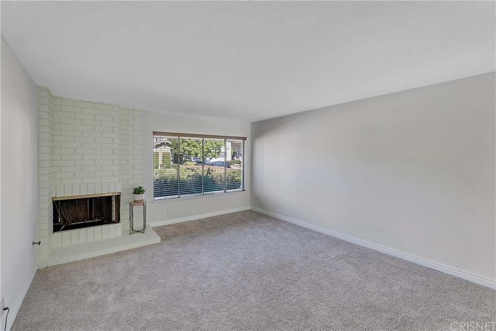 23646 Vía Corsa Valencia, CA 91355 - Photo 6 of 55 a view of an empty room with a fireplace and a window
