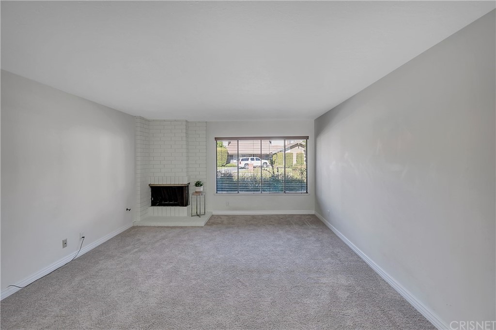23646 Vía Corsa Valencia, CA 91355 - Photo 7 of 55 an empty room with a fireplace and a window