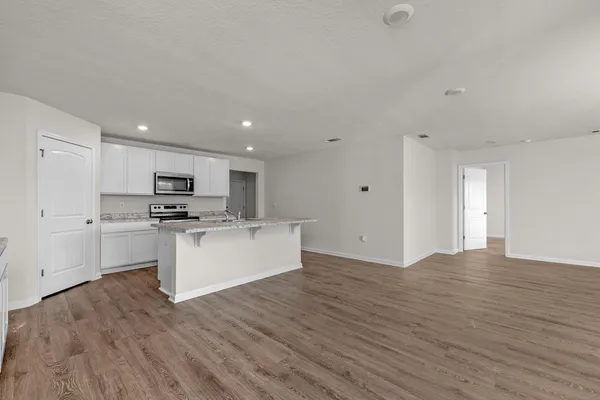 a view of kitchen with granite countertop cabinets and white appliances