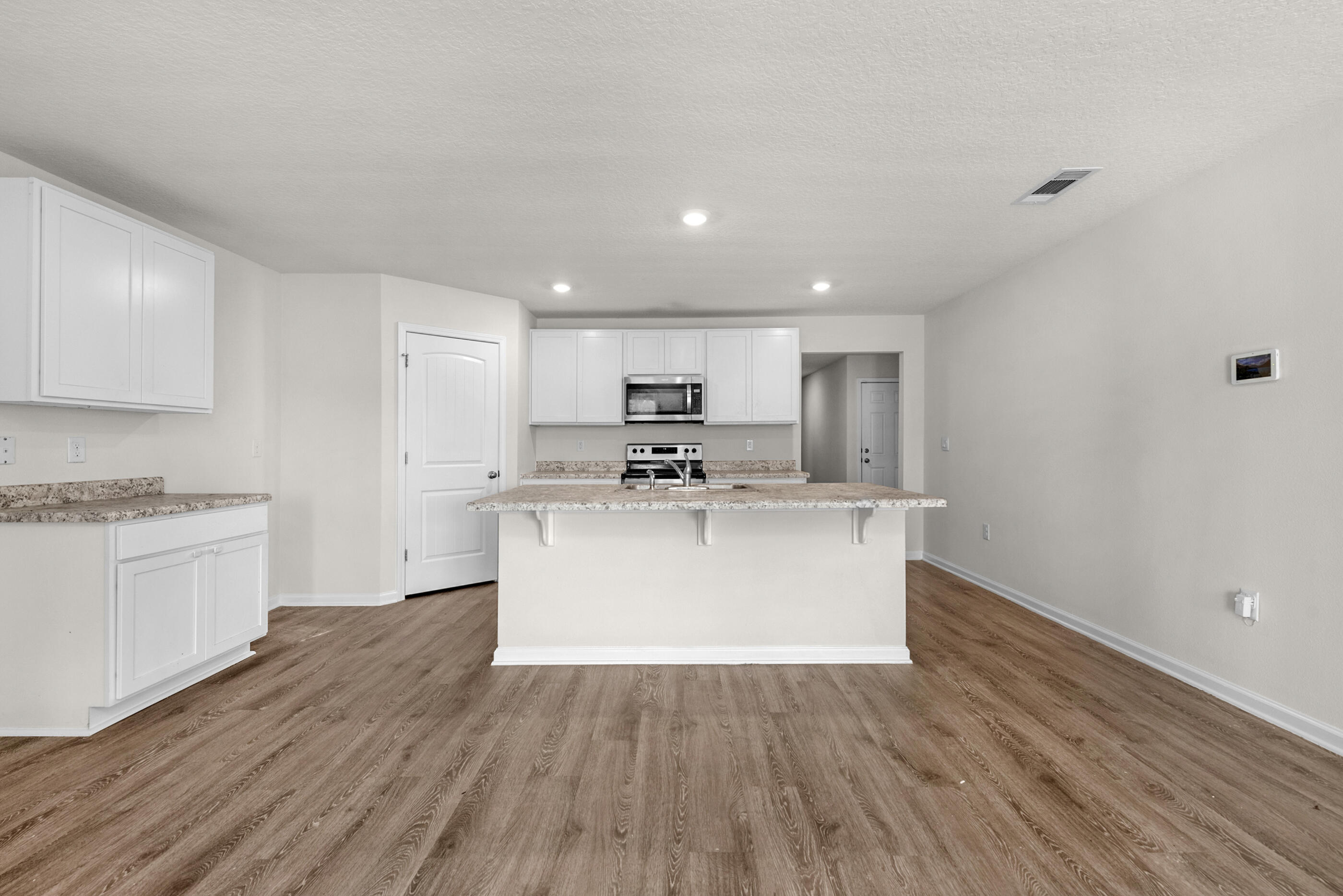 3524 Sugar Maple Lane Crestview, FL 32539 - Photo 7 of 24 a view of a kitchen with wooden floor and stainless steel appliances