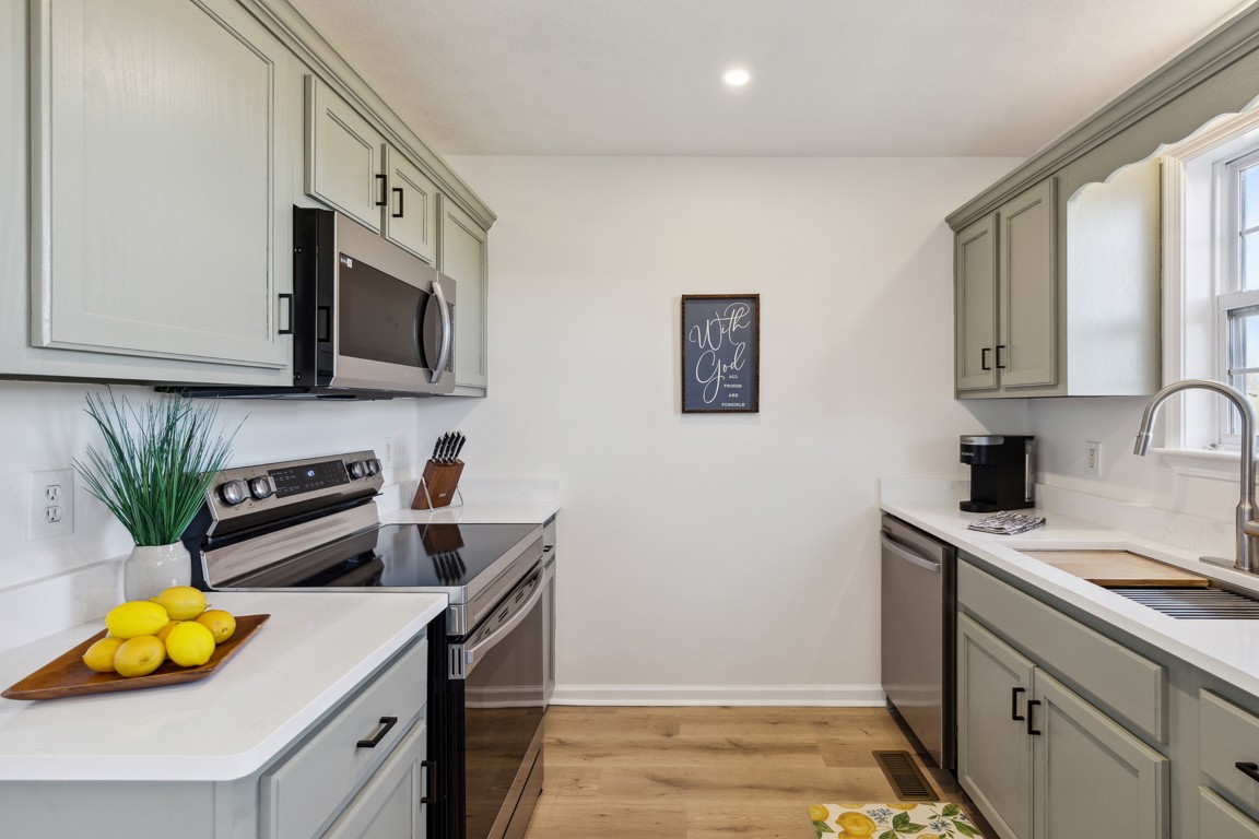 486 Berry Circle Springfield, TN 37172 - Photo 9 of 27 a kitchen with stainless steel appliances granite countertop a sink a stove and a microwave