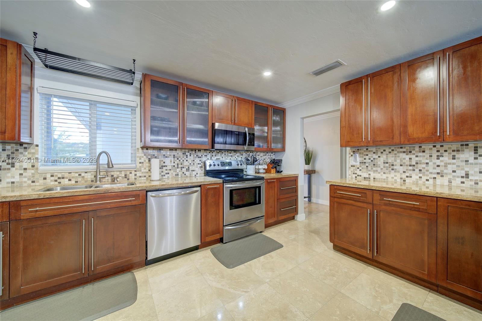 10600 Southwest 108th Terrace Miami, FL 33176 - Photo 14 of 43 a kitchen with stainless steel appliances granite countertop wooden cabinets a sink and a stove