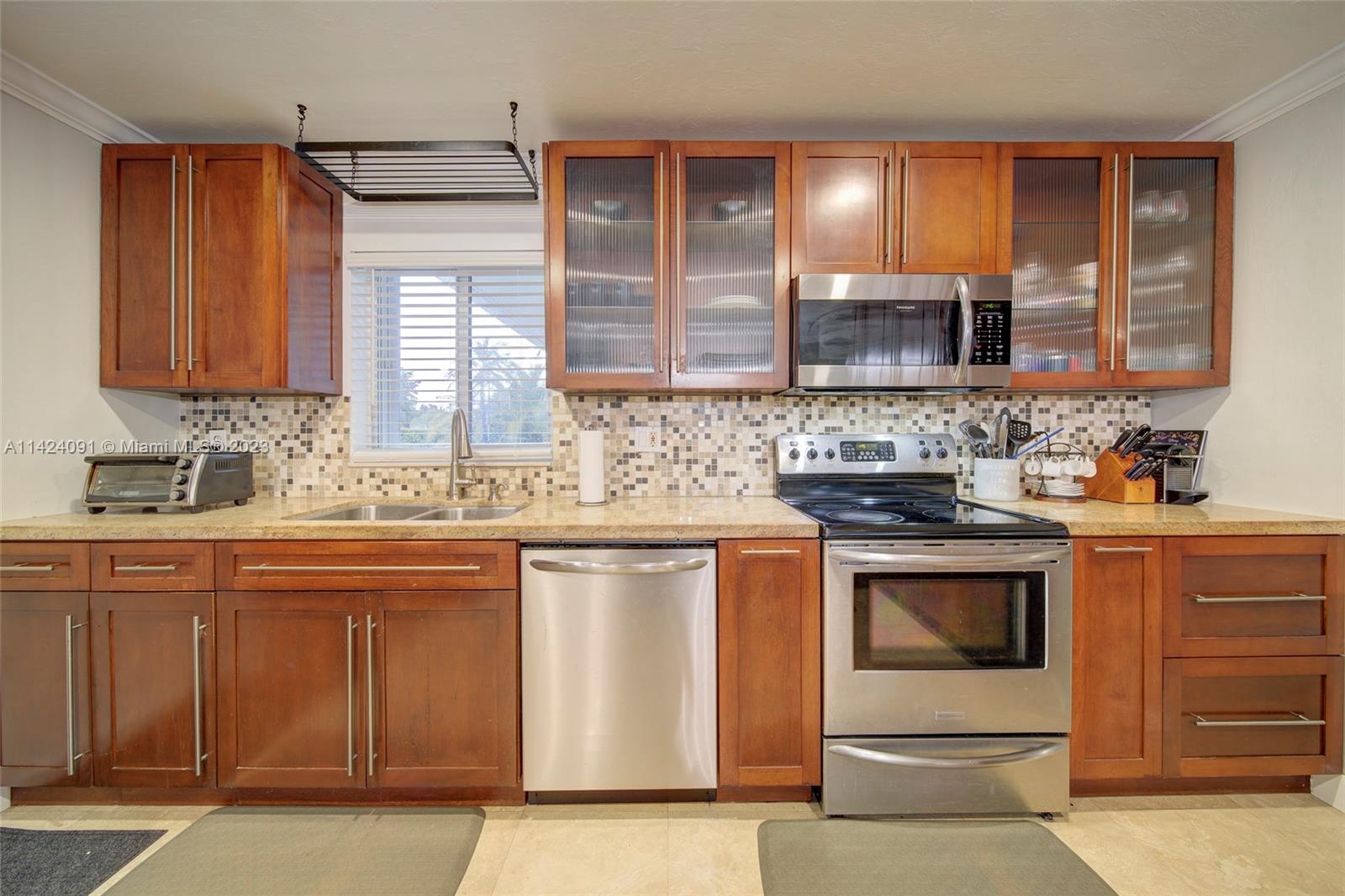 10600 Southwest 108th Terrace Miami, FL 33176 - Photo 15 of 43 a kitchen with stainless steel appliances granite countertop a sink stove and cabinets