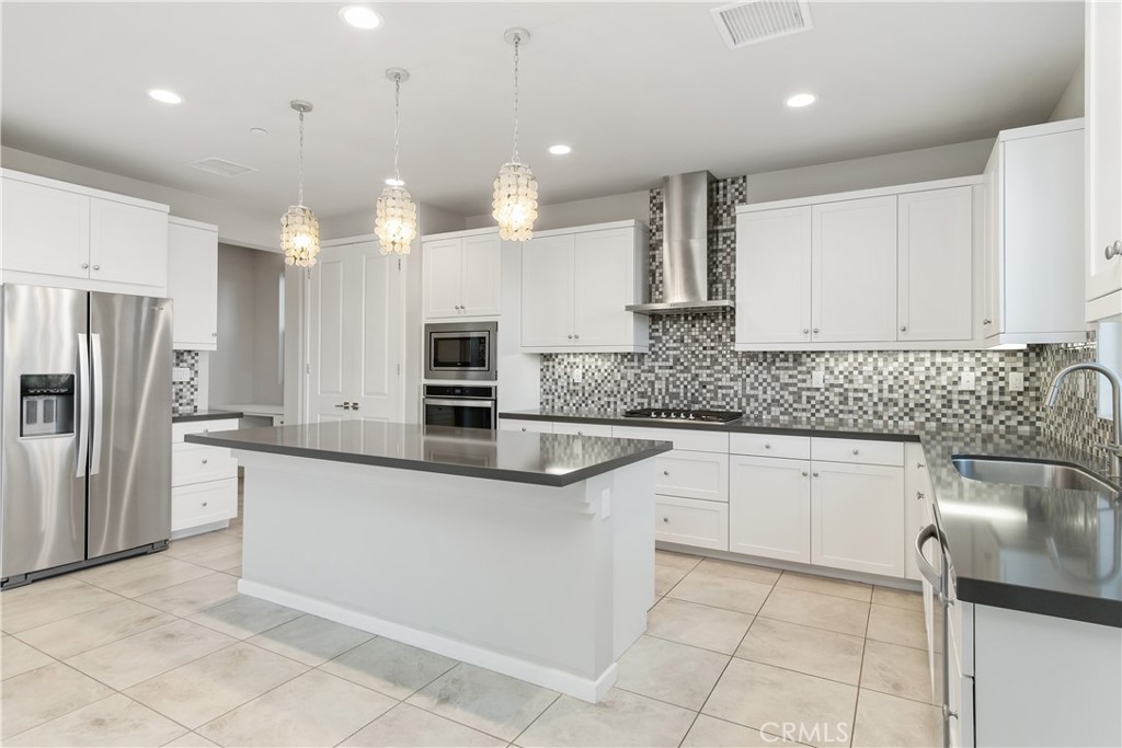 a kitchen with kitchen island granite countertop a sink counter top space appliances and cabinets