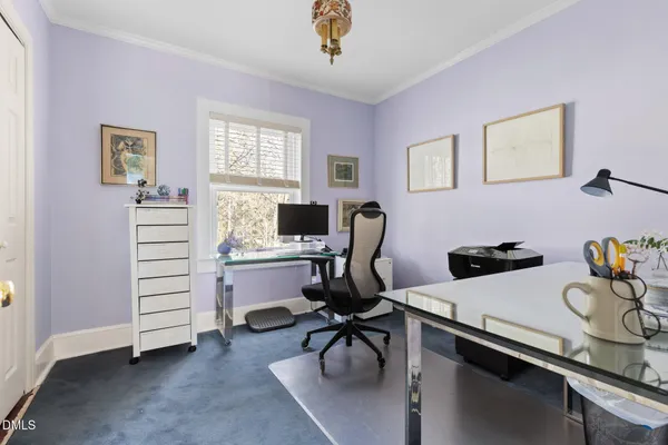 a view of a workspace with furniture and a window